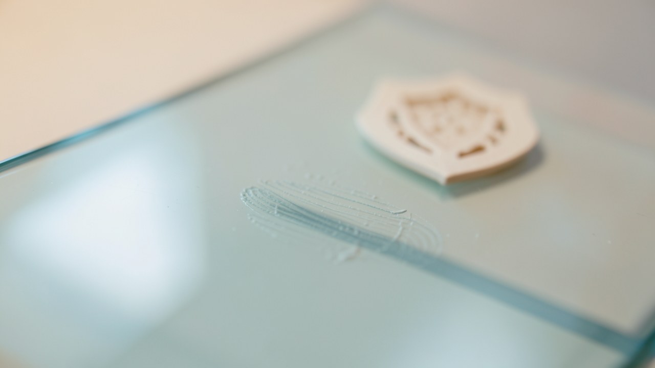 A fingerprint on a glass surface with a small shield icon, on a clean background, symbolizing credit security.